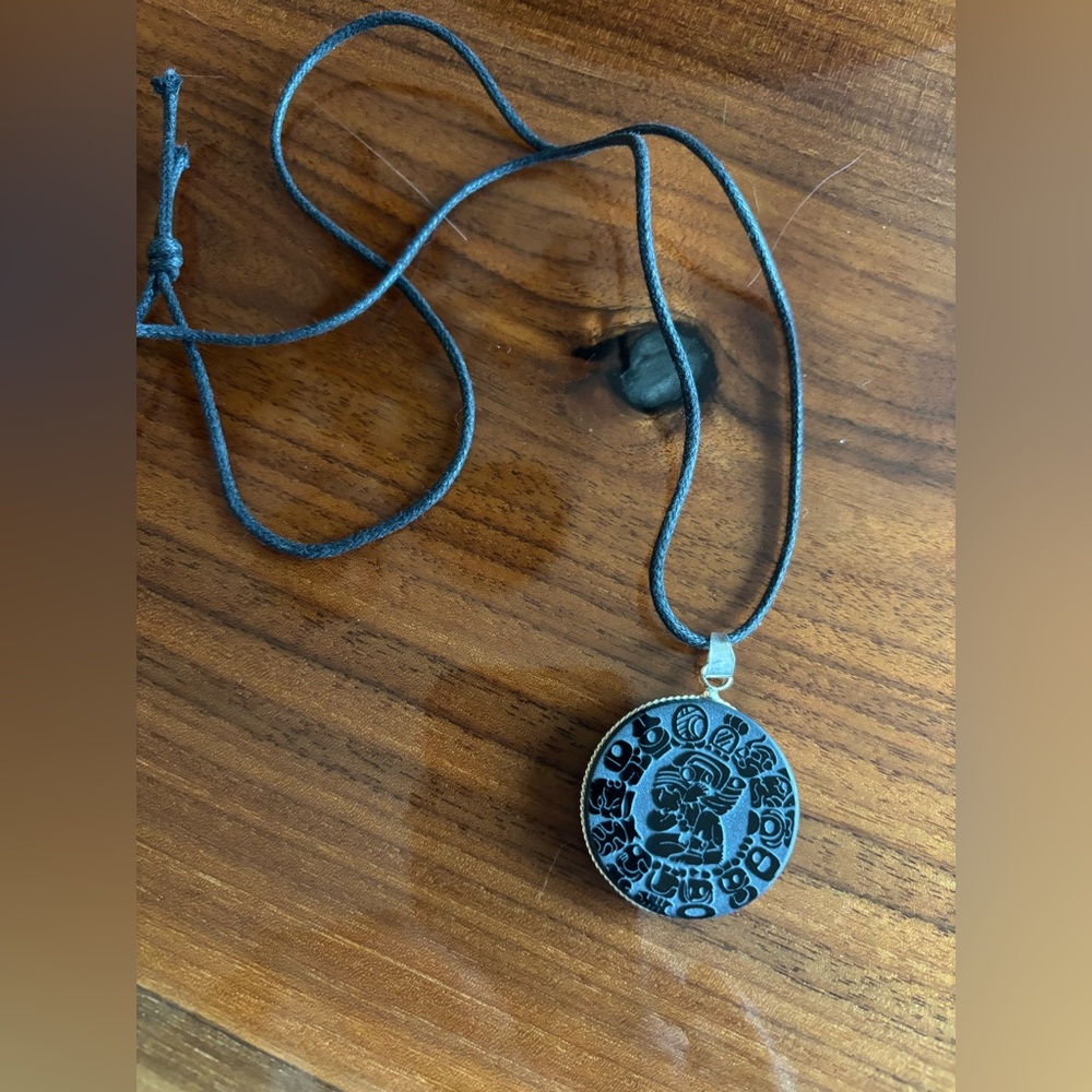 Mayan calendar pendent necklace on black cord purchased from  Yucatán Penninsula